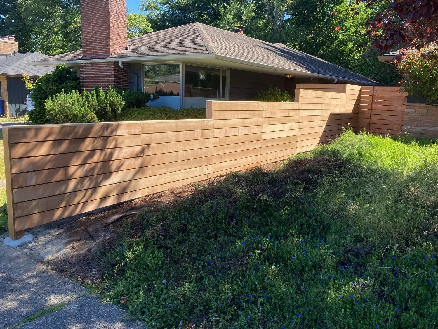 Horizontal wood fence diving a house and the neighboring lot